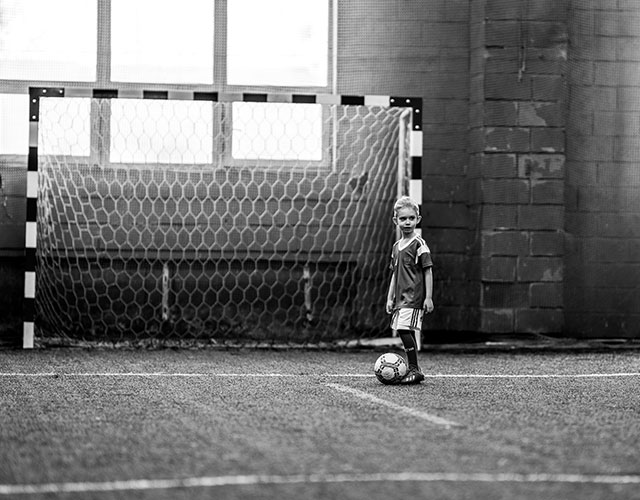 Football Player kicking football to the goal net 